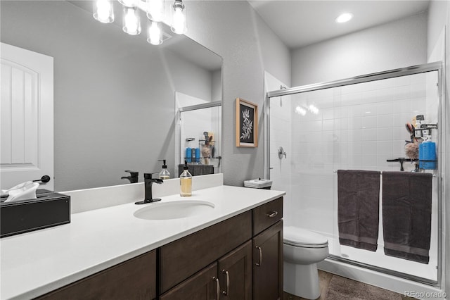 bathroom with vanity, an enclosed shower, and toilet