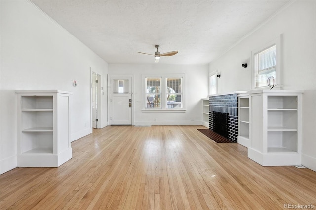 unfurnished living room featuring a textured ceiling, light hardwood / wood-style flooring, and a wealth of natural light