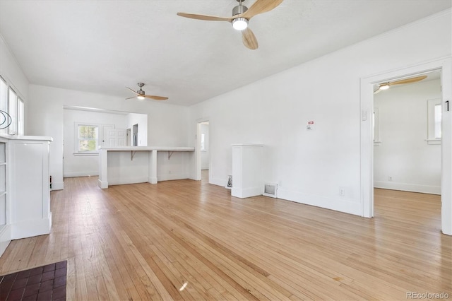 unfurnished living room with light wood-type flooring and ceiling fan