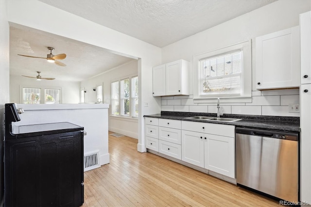 kitchen featuring decorative backsplash, light hardwood / wood-style floors, white cabinets, stainless steel dishwasher, and sink