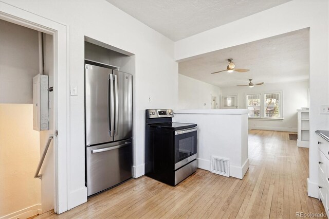 kitchen with appliances with stainless steel finishes, white cabinets, ceiling fan, light hardwood / wood-style flooring, and electric panel