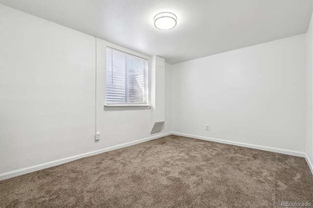 spare room with a textured ceiling and carpet flooring