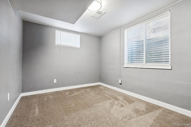 spare room featuring carpet floors and a textured ceiling