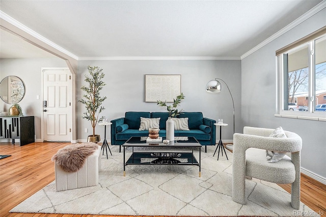 living room with baseboards, wood finished floors, and ornamental molding