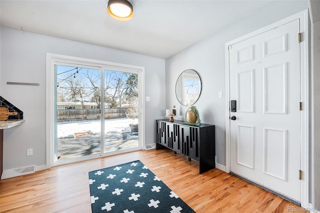 entrance foyer with light wood-style floors, baseboards, and visible vents