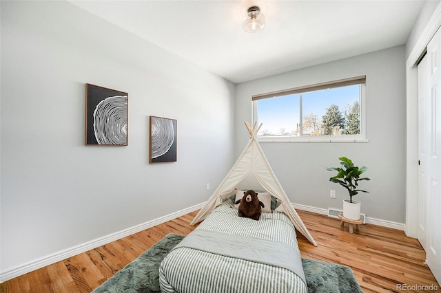 bedroom with a closet, baseboards, and wood finished floors