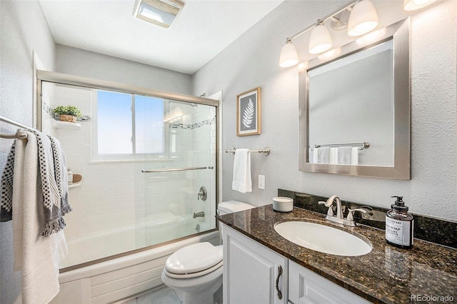 bathroom with shower / bath combination with glass door, vanity, and toilet