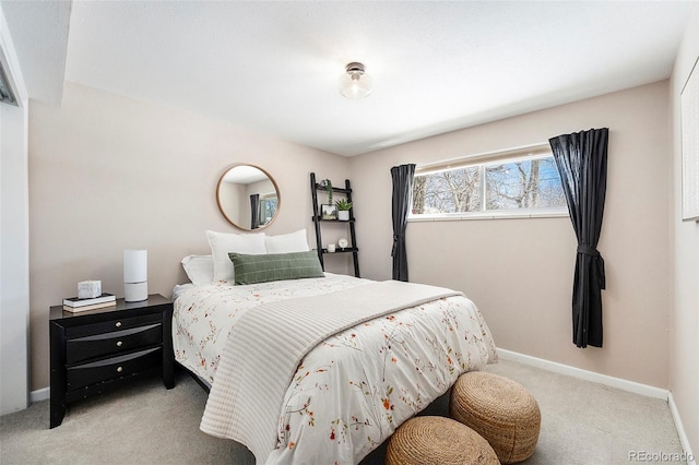 bedroom with light carpet and baseboards