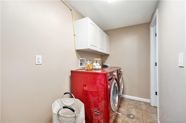 laundry area featuring washer and clothes dryer, cabinet space, and baseboards