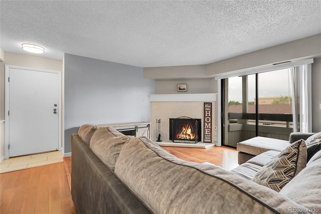 14214 E 1st Dr Unit B08, Aurora, CO 80011 - living room featuring a fireplace, wood finished floors, and a textured ceiling