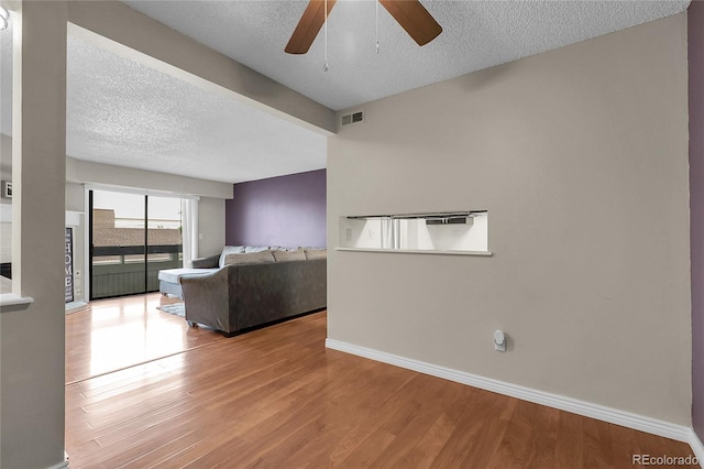 14214 E 1st Dr Unit B08, Aurora, CO 80011 - unfurnished living room featuring a textured ceiling, ceiling fan, and wood finished floors