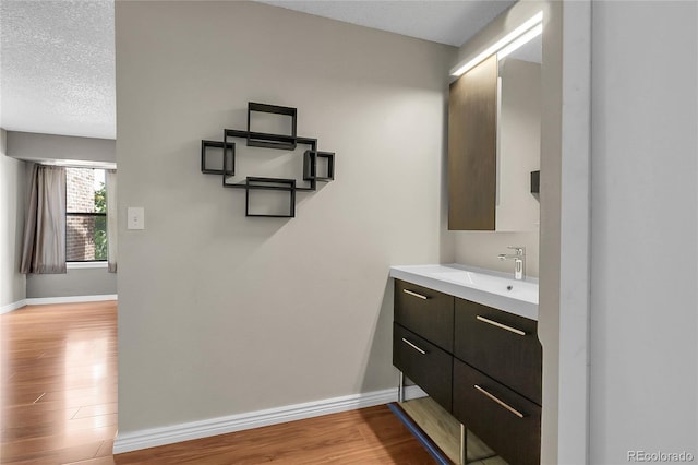 14214 E 1st Dr Unit B08, Aurora, CO 80011 - bathroom featuring wood finished floors, vanity, and a textured ceiling