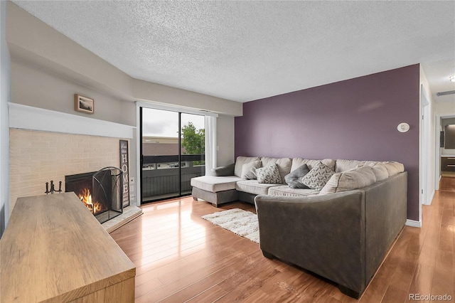 14214 E 1st Dr Unit B08, Aurora, CO 80011 - living area with a fireplace, wood finished floors, and a textured ceiling