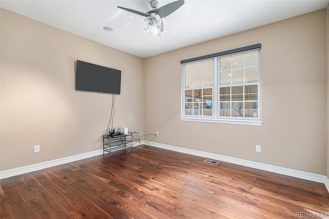 spare room featuring dark hardwood / wood-style flooring and ceiling fan