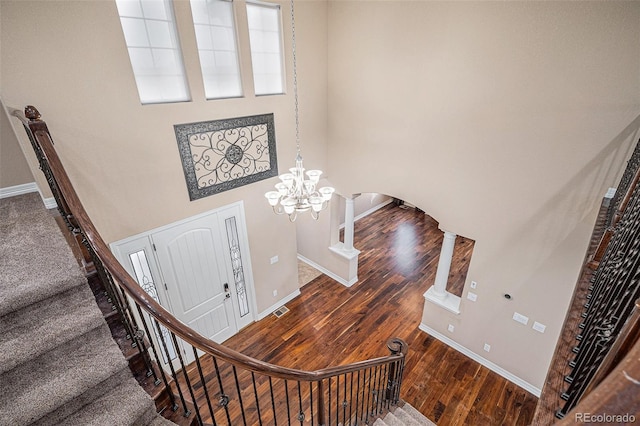 stairs featuring an inviting chandelier and hardwood / wood-style flooring