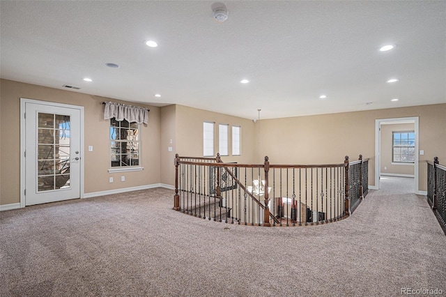 hall with carpet and a textured ceiling