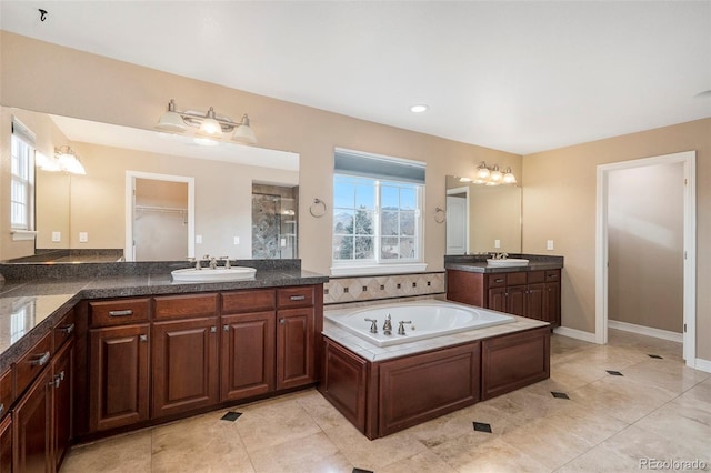 bathroom with tile patterned floors, vanity, a healthy amount of sunlight, and a bath