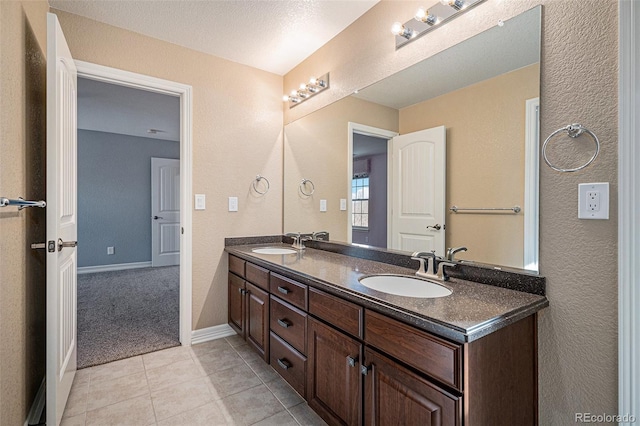 bathroom featuring tile patterned flooring, vanity, and a textured ceiling