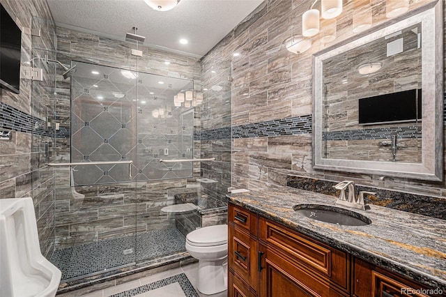 bathroom featuring tile patterned floors, vanity, a textured ceiling, a shower with door, and toilet