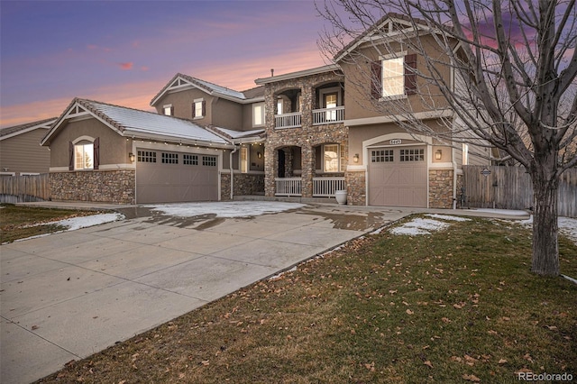 view of front facade featuring covered porch, a yard, a balcony, and a garage