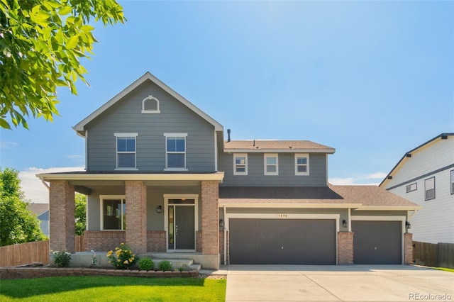 5894 Graphite St, Timnath, CO 80547 - view of front of home featuring brick siding, a porch, driveway, and an attached garage
