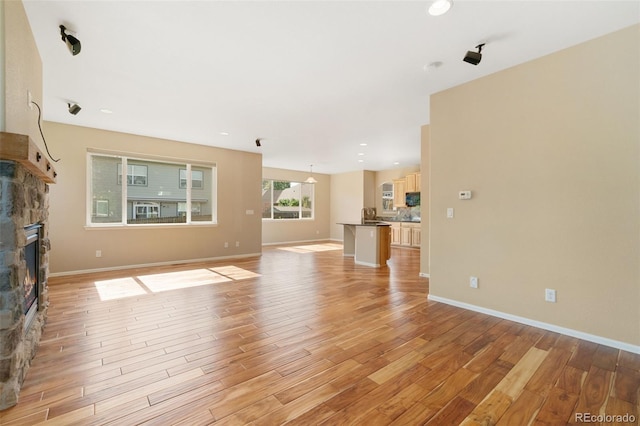 5894 Graphite St, Timnath, CO 80547 - unfurnished living room featuring light wood-style floors, a fireplace, and recessed lighting