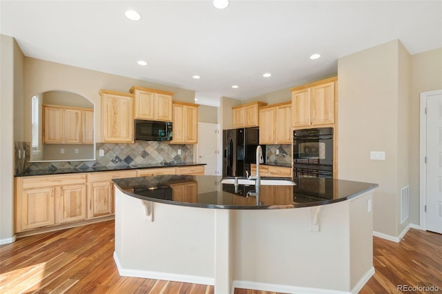5894 Graphite St, Timnath, CO 80547 - kitchen with black appliances, light brown cabinetry, dark countertops, tasteful backsplash, and recessed lighting