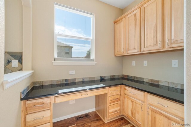 5894 Graphite St, Timnath, CO 80547 - kitchen with light brown cabinets, built in study area, dark countertops, and wood finished floors