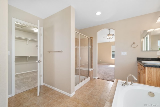 5894 Graphite St, Timnath, CO 80547 - full bathroom featuring a shower stall, vanity, a spacious closet, a bath, and ceiling fan