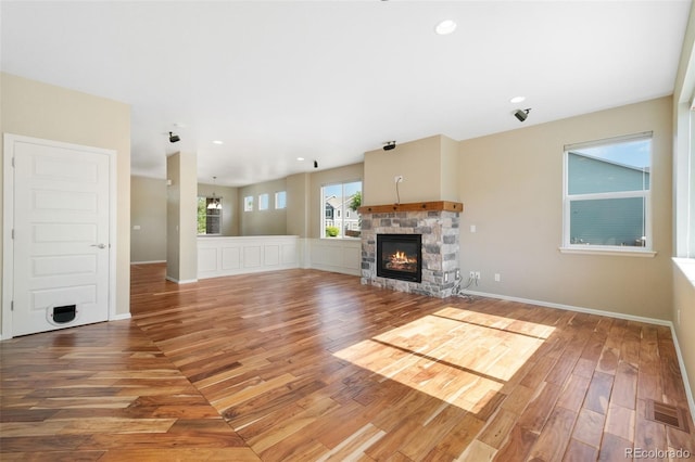 5894 Graphite St, Timnath, CO 80547 - unfurnished living room with wood finished floors, a stone fireplace, and recessed lighting