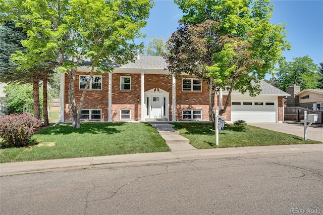 6842 Garland St, Arvada, CO 80004 - split foyer home with concrete driveway, brick siding, and a garage