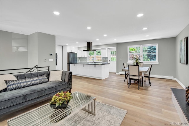 6842 Garland St, Arvada, CO 80004 - living area with recessed lighting, light wood-style flooring, and a baseboard radiator