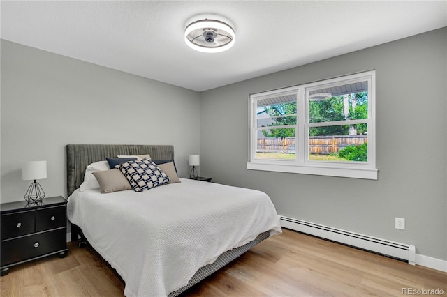 6842 Garland St, Arvada, CO 80004 - bedroom featuring a baseboard heating unit and wood finished floors