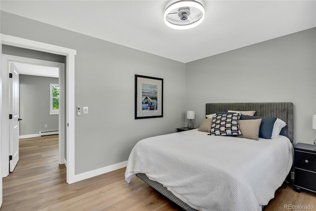 6842 Garland St, Arvada, CO 80004 - bedroom featuring a baseboard heating unit and wood finished floors
