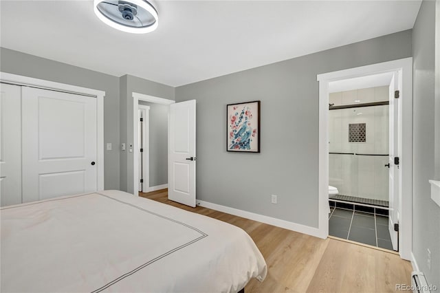 6842 Garland St, Arvada, CO 80004 - bedroom with wood finished floors, a closet, a baseboard radiator, and ensuite bathroom