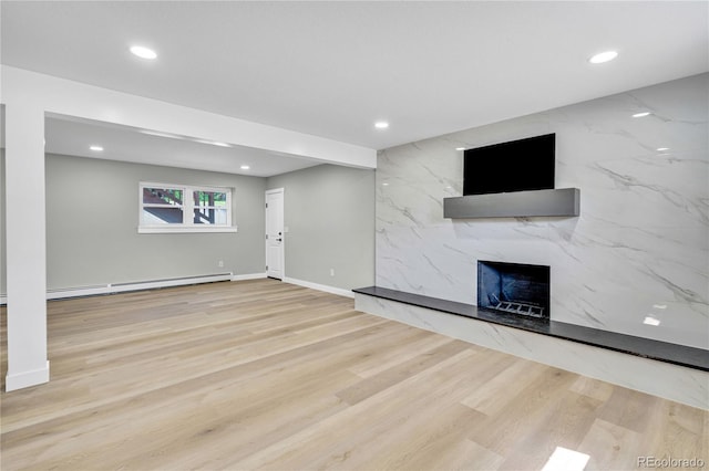 6842 Garland St, Arvada, CO 80004 - unfurnished living room with a high end fireplace, a baseboard heating unit, recessed lighting, and wood finished floors