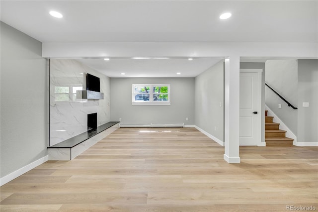 6842 Garland St, Arvada, CO 80004 - unfurnished living room with a baseboard heating unit, stairway, light wood finished floors, a fireplace, and recessed lighting