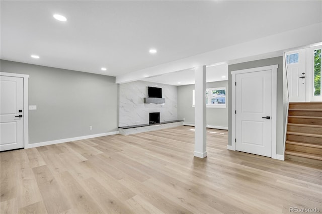 6842 Garland St, Arvada, CO 80004 - unfurnished living room with plenty of natural light, recessed lighting, a premium fireplace, and light wood-style floors