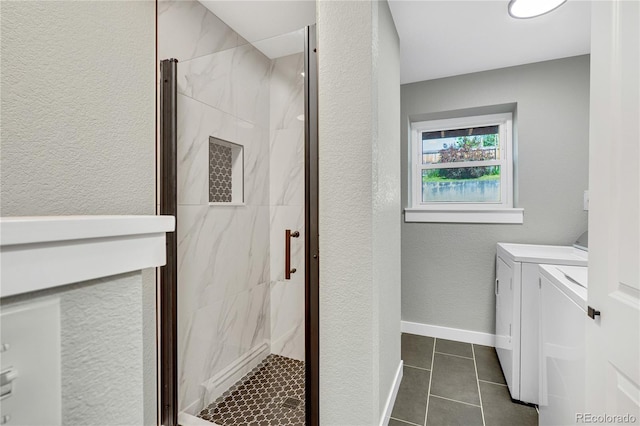 6842 Garland St, Arvada, CO 80004 - washroom featuring washer and dryer, dark tile patterned flooring, and a textured wall