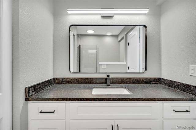 6842 Garland St, Arvada, CO 80004 - bathroom featuring vanity and a textured wall