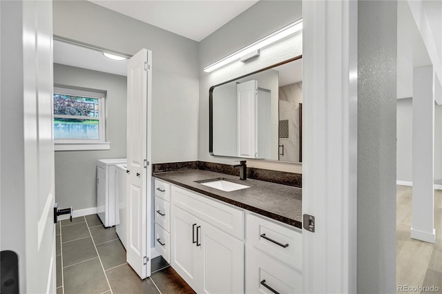 6842 Garland St, Arvada, CO 80004 - full bathroom with washing machine and clothes dryer, vanity, tile patterned floors, and tiled shower