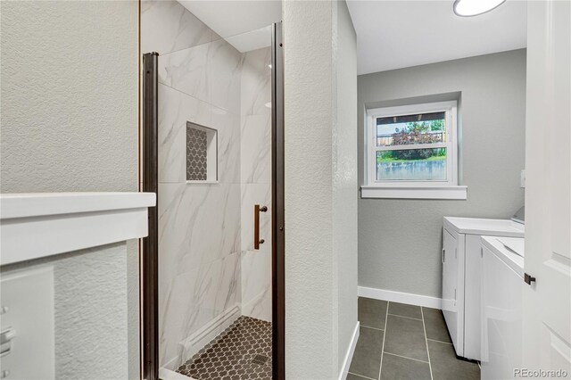 6842 Garland St, Arvada, CO 80004 - washroom featuring washer and dryer, dark tile patterned flooring, and a textured wall