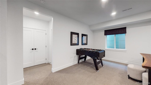 recreation room featuring light colored carpet