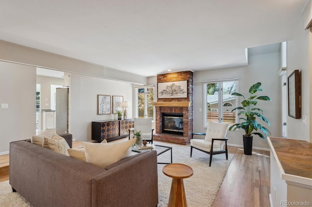 living area with light wood-type flooring, a fireplace, and baseboards