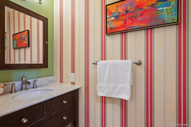bathroom featuring wallpapered walls and vanity