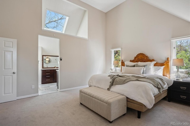 bedroom featuring high vaulted ceiling, light carpet, connected bathroom, and baseboards