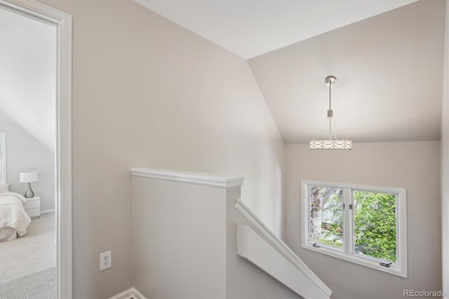 staircase featuring lofted ceiling, carpet floors, and baseboards