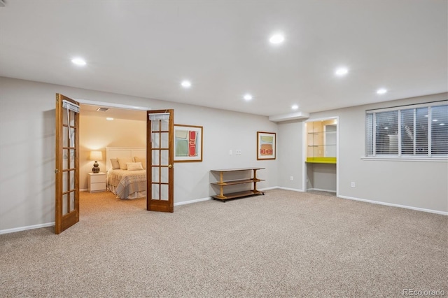 finished below grade area with french doors, carpet flooring, recessed lighting, and baseboards
