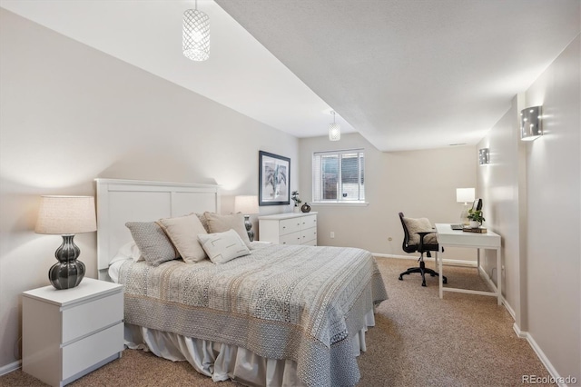 bedroom with light colored carpet, a desk, and baseboards