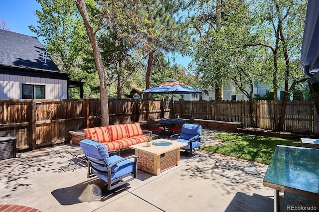 view of patio / terrace with a fenced backyard and an outdoor living space with a fire pit
